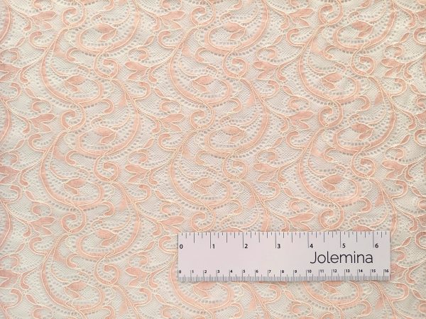 peachy pink stretch allover corded lace fabric with ruler